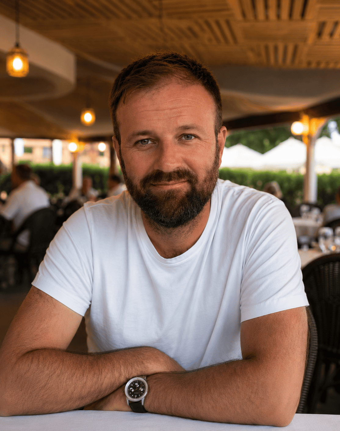 Bearded man sitting at outdoor restaurant | Home Service (About)